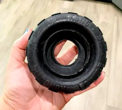 a person holding a kong tire toy