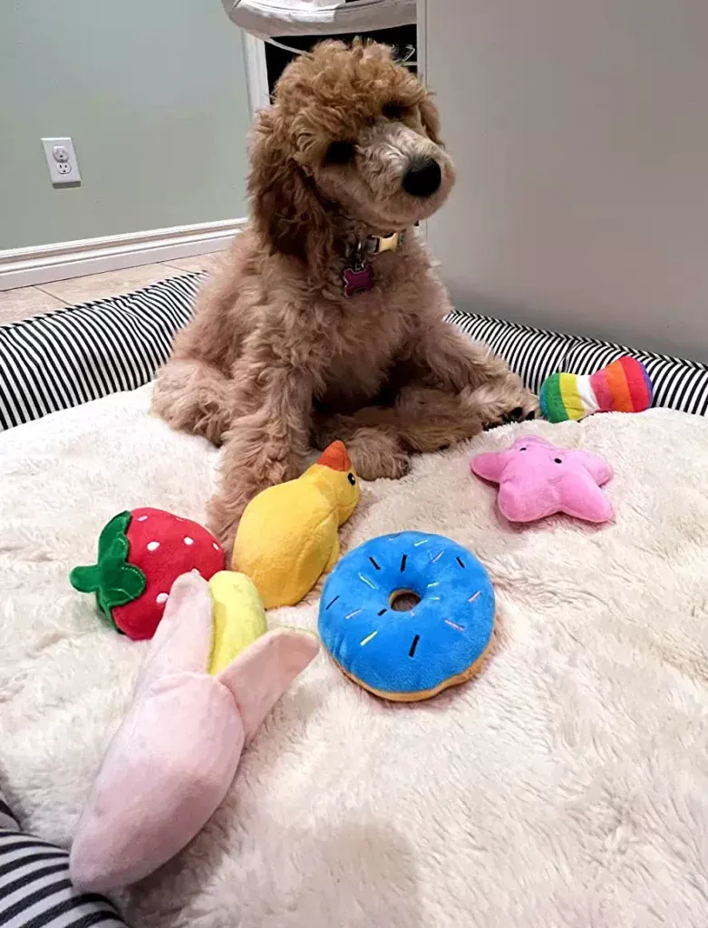 a dog sitting on a bed with stuffed animals